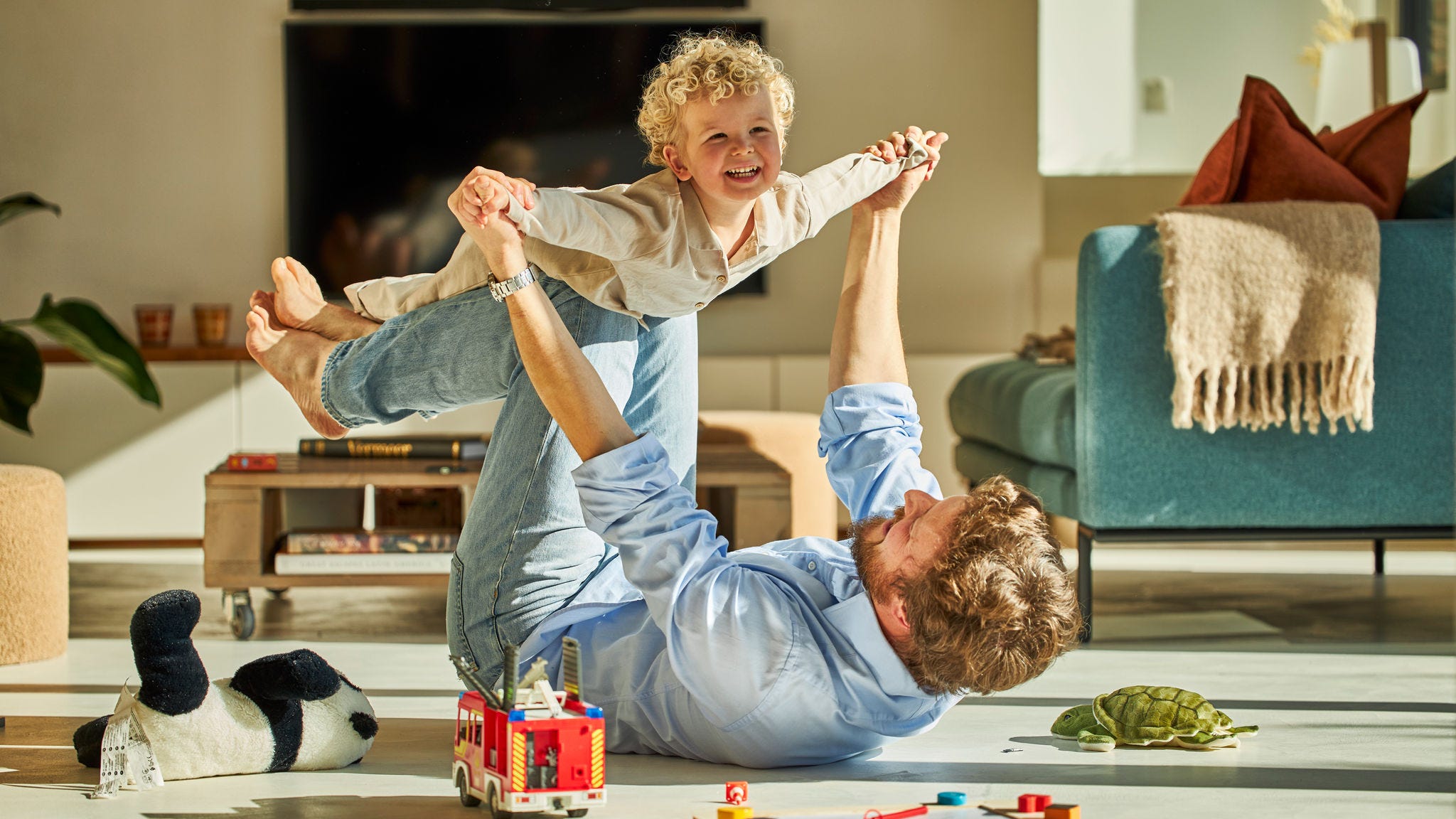 Татко со своето дете си играат среќно заедно и уживаат во топлината на подното греење