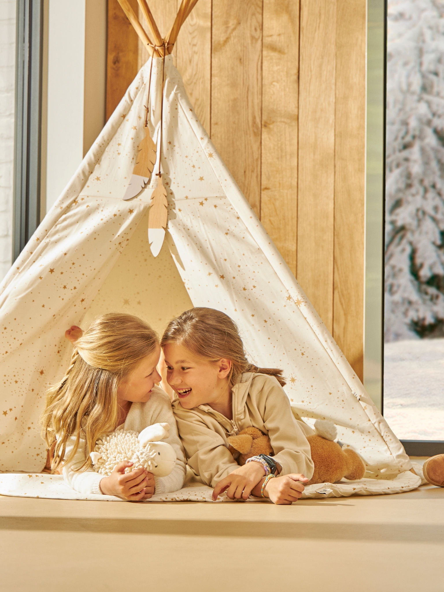 Две мали деца си играат среќно во својот шатор внатре на совршена температура