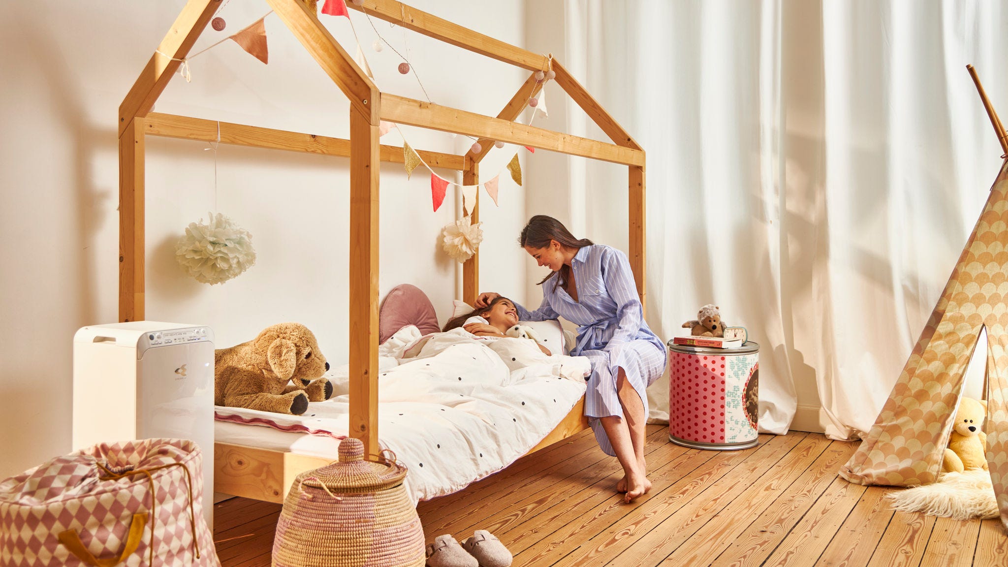 Мајка го легнува своето дете во кревет во нивниот здрав дом благодарение на прочиставчот на воздух од Daikin во детската соба