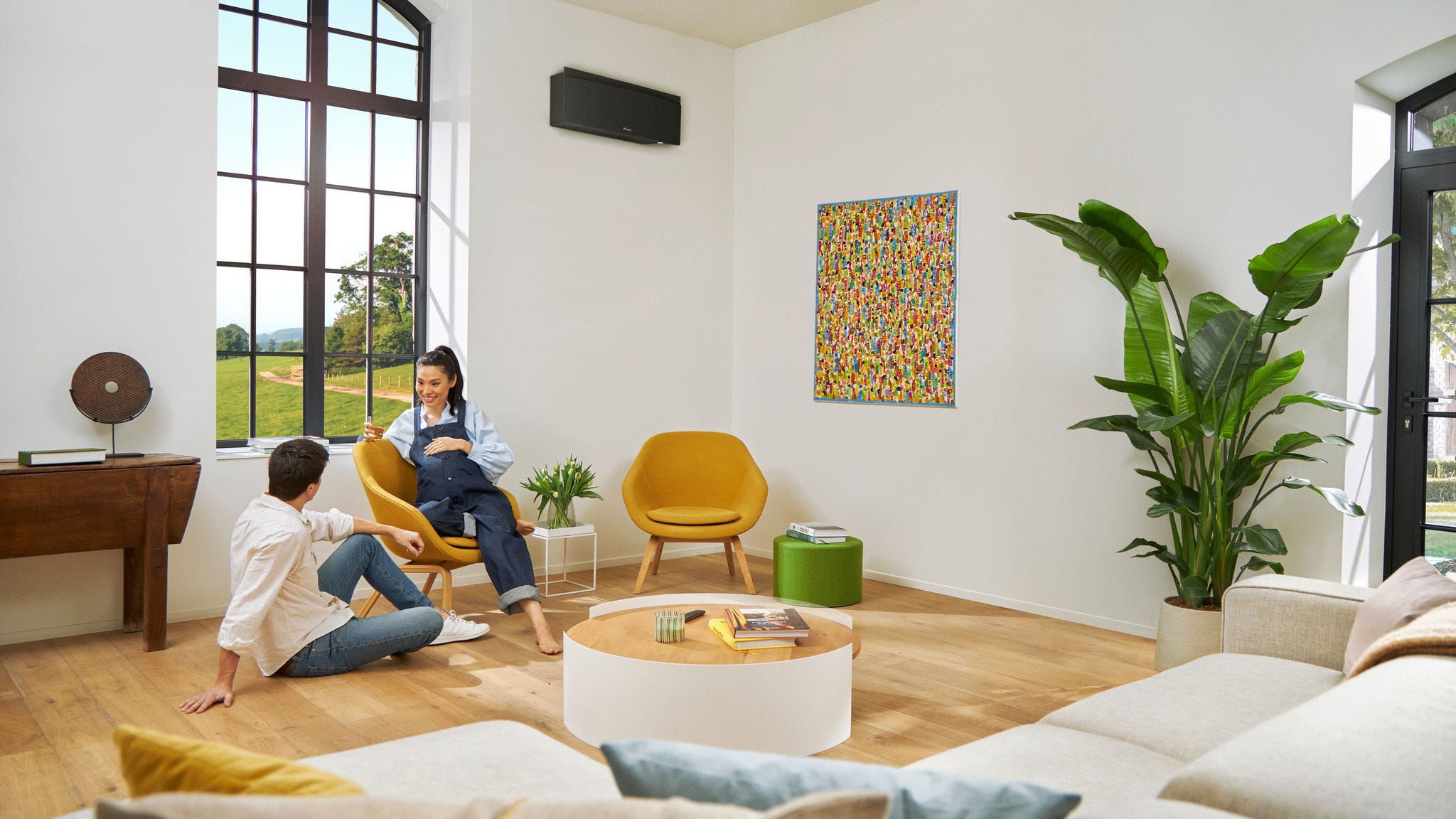 Бремена двојка разговара релаксирано додека жената седи на стол