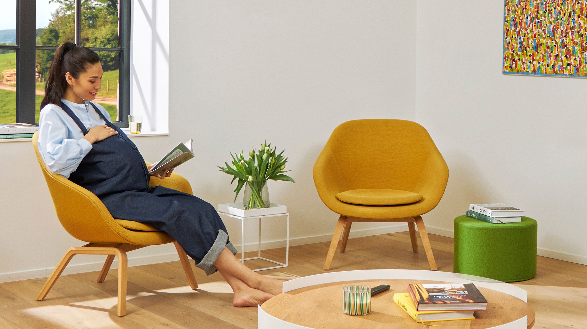 Бремена жена чита книга во нејзиното столче и ужива во чистиот воздух во дневната соба