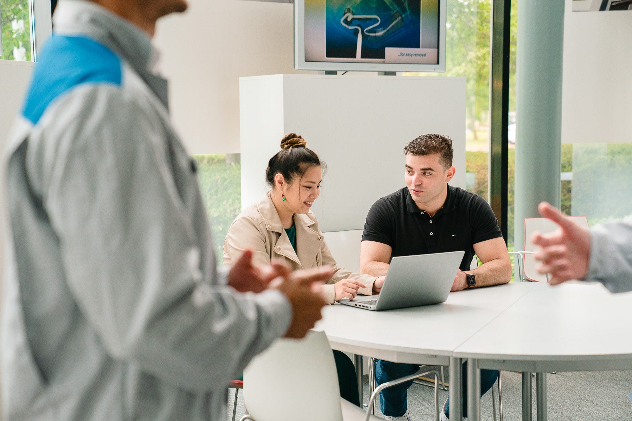 Жена му објаснува нешто на маж на лаптоп