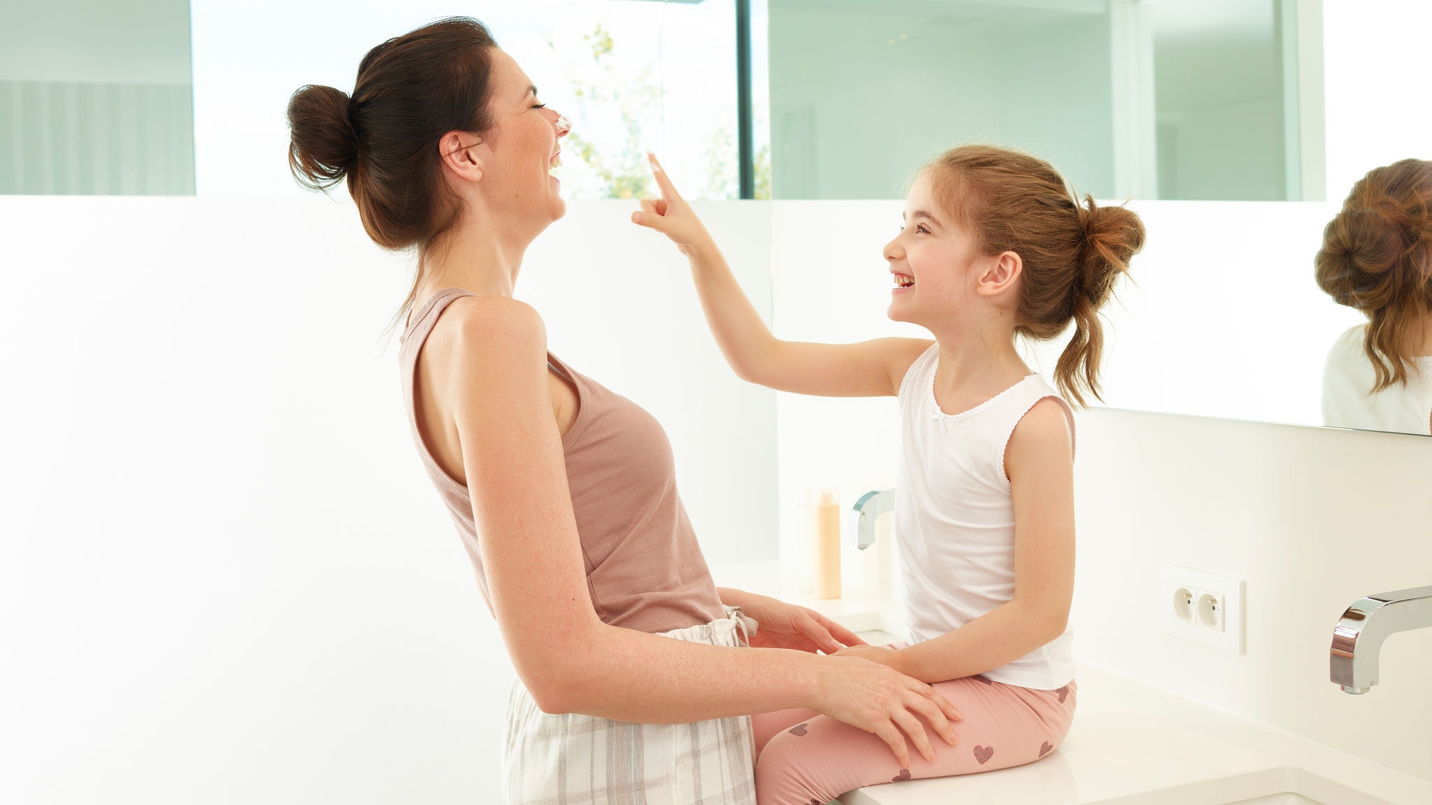 Мајка и ќерка си играат во бањата