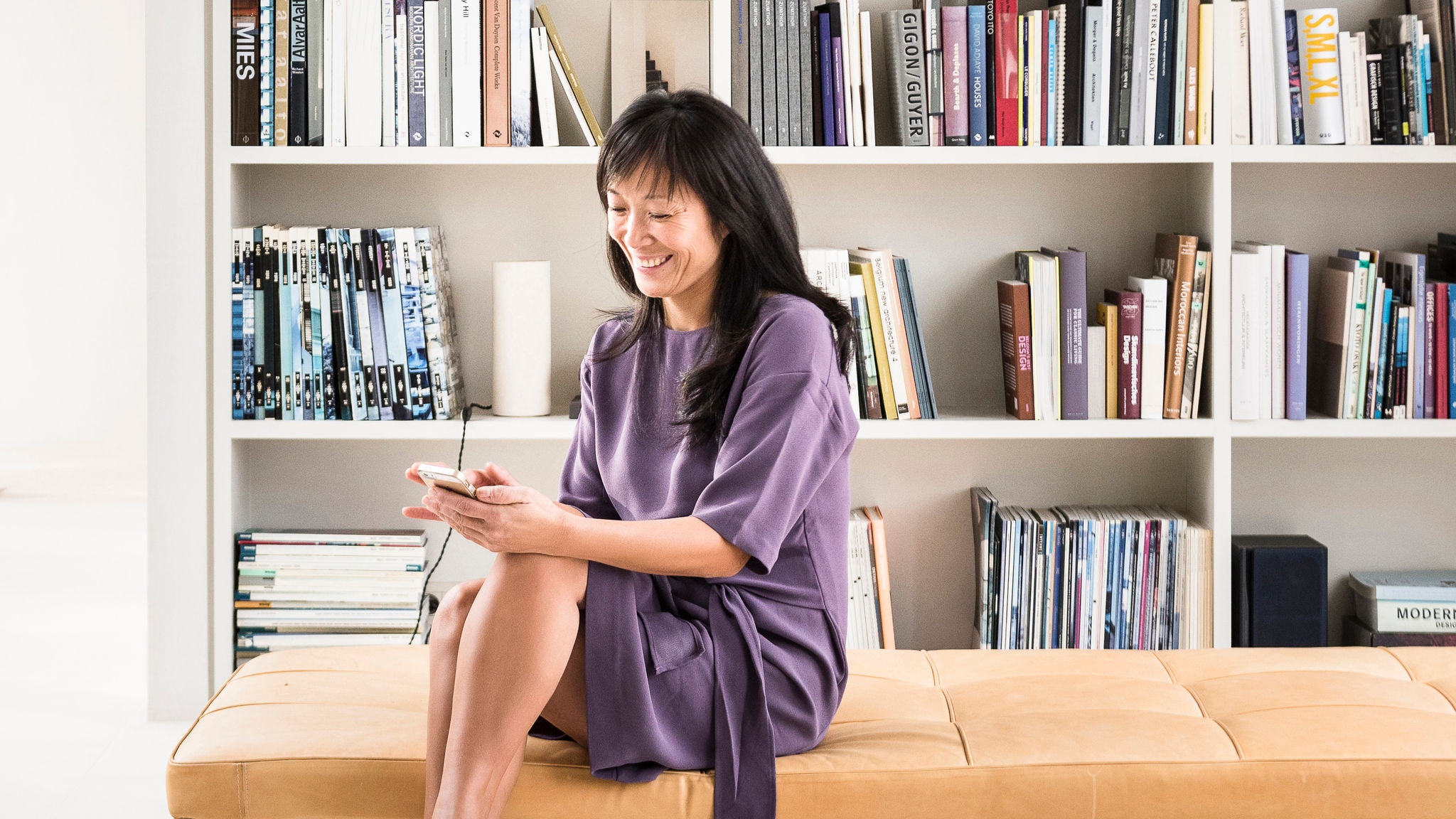 Жена користи апликација Onecta за да контролира греење, ладење и топла вода во својот дом