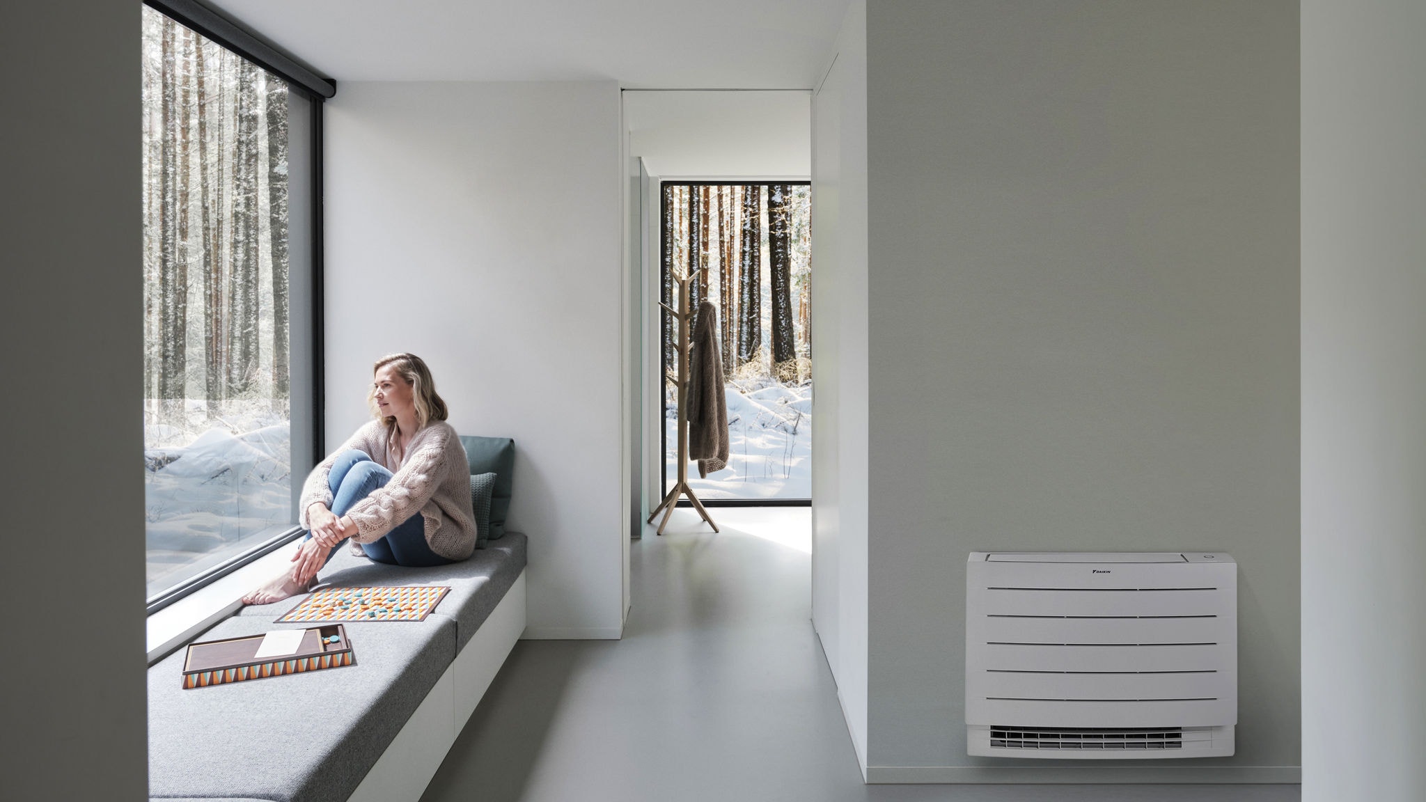 Жена гледа со отворена уста во белата снежна покривка надвор од нејзината куќа и ужива во загреан дом, благодарение на парапетната единица Perfera