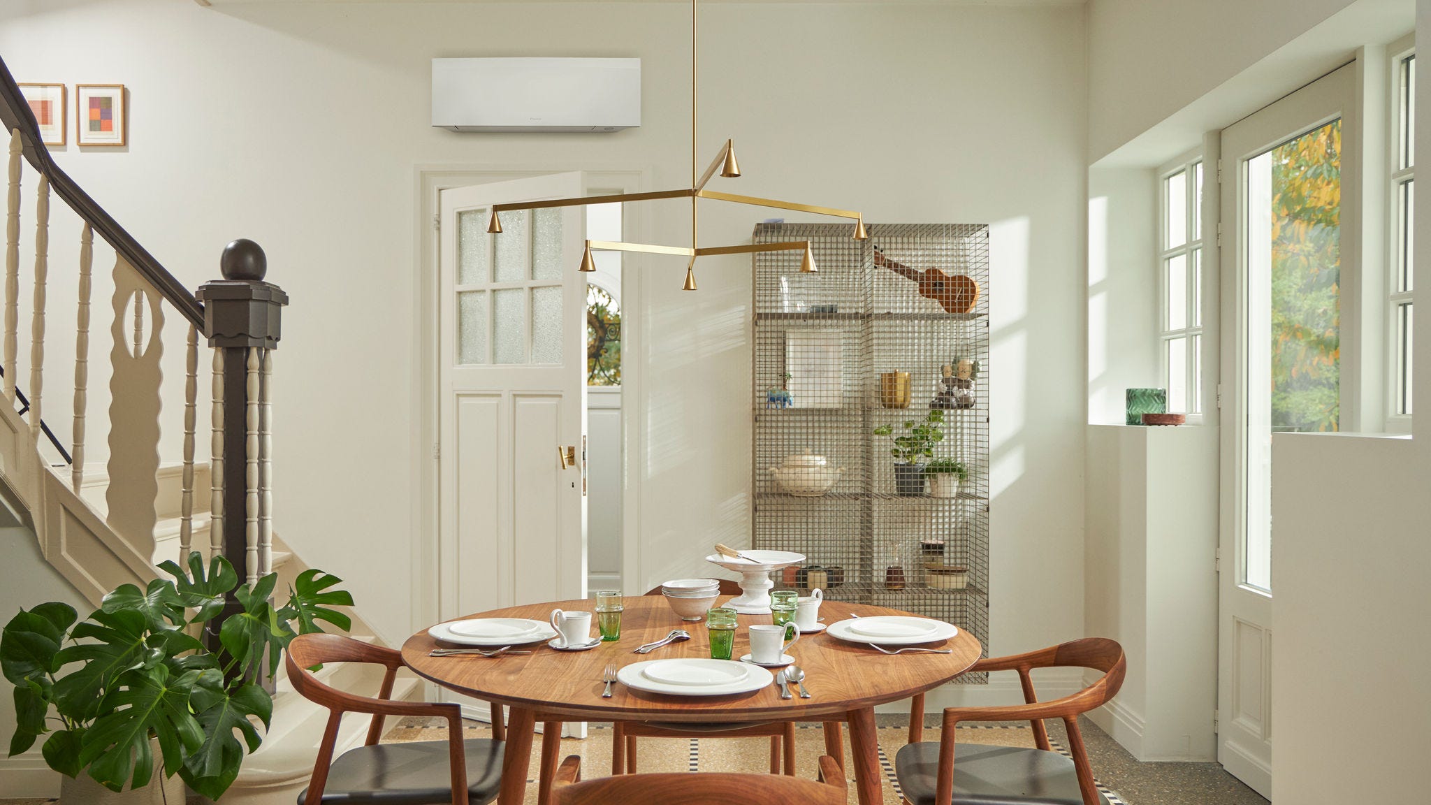 Соба со голем прозорец, дрвена маса и високоѕидно климатско решение во црна боја