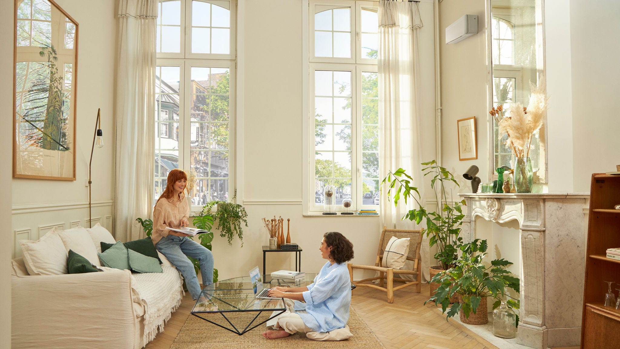 Woman sitting in the living room comfortably thanks to Daikin air-to-air heatpums