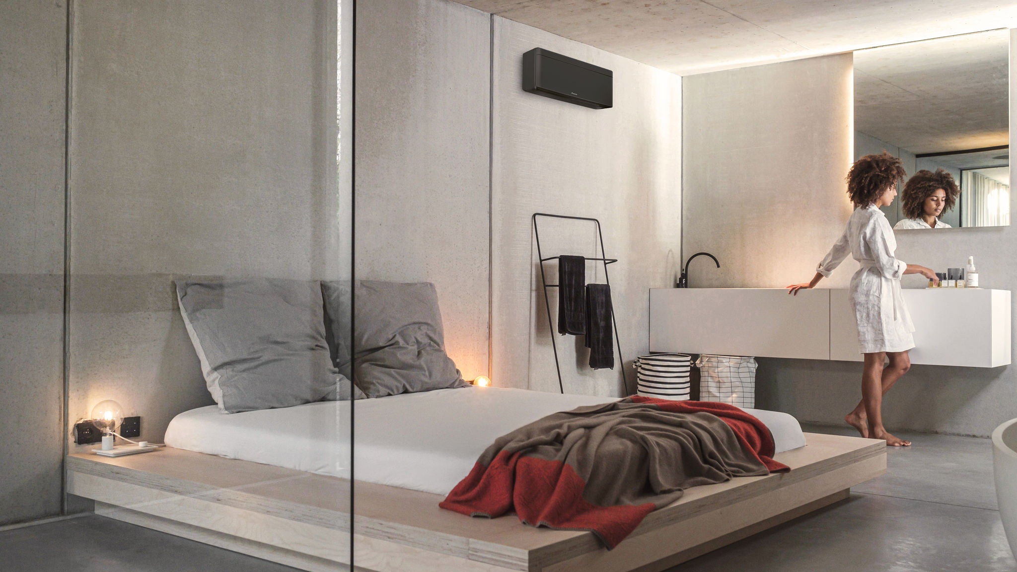 A woman in her bedroom with a stylish Daikin air conditioner